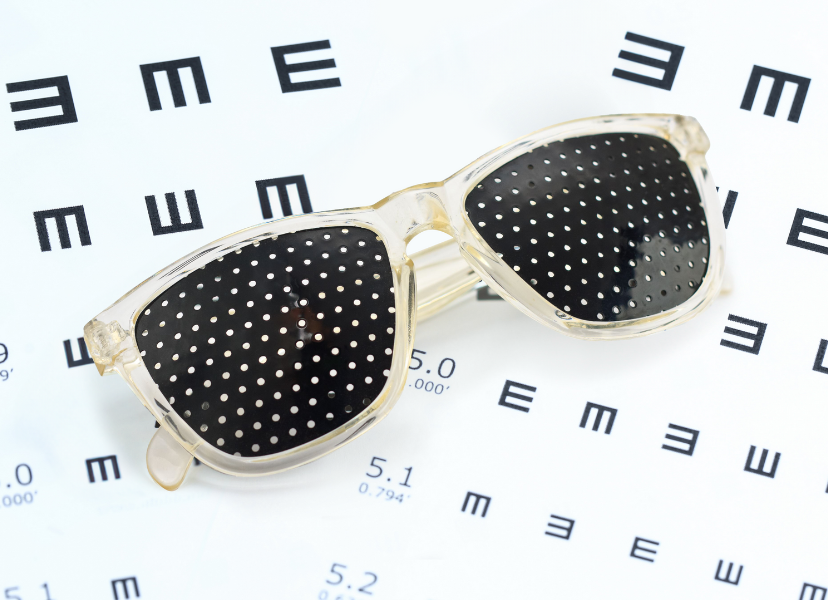 pinhole glasses on an eye exam chart