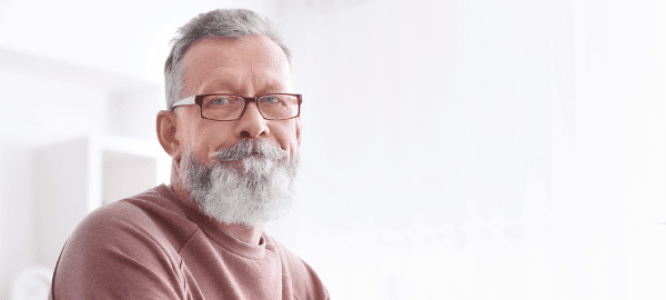 man with beard with glasses sitting at pc