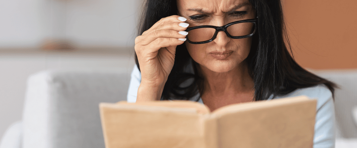 woman reading adjusting glasses