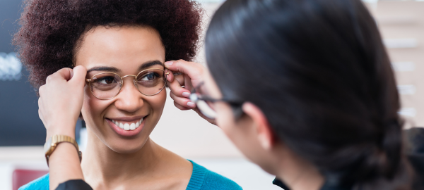 woman trying on glasses with optician