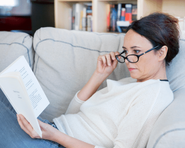 woman reading book wearing glasses