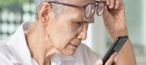 elderly women with myopia putting on glasses to read phone