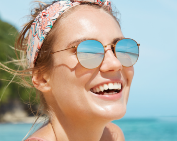 woman at beach wearing mirrored sunglasses