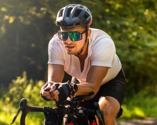 male cyclist wearing single lens sunglasses while riding bike