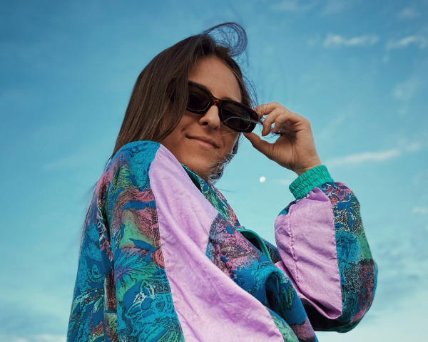 woman wearing a 90s inspired windbreaker and rectangular sunglasses