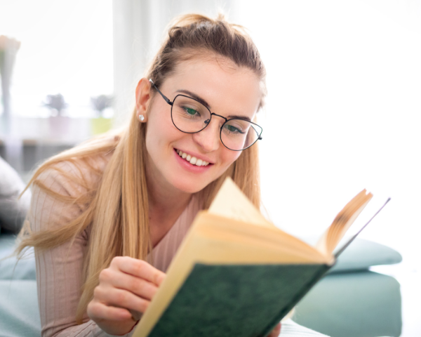 girl reading a book with glasses