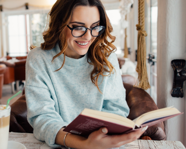 girl reading a book in glasses