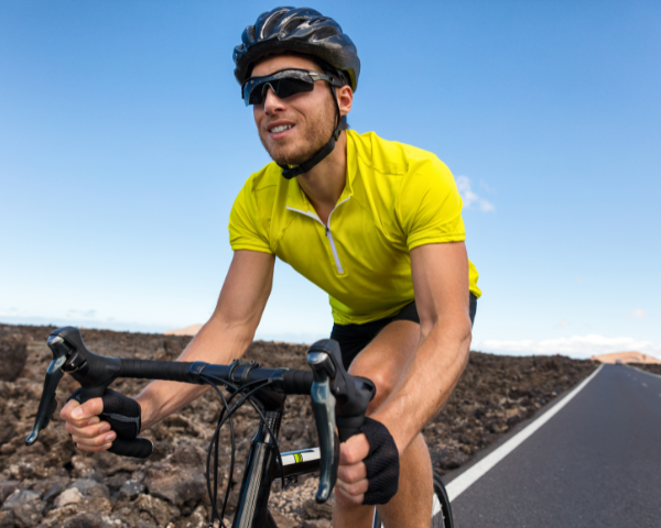 cycling athlete riding a bike outdoors and wearing sports sunglasses