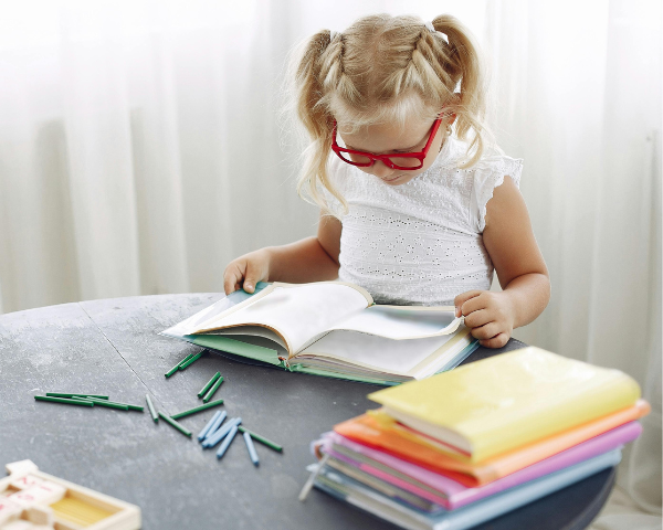 young girl wearing glasses and reading