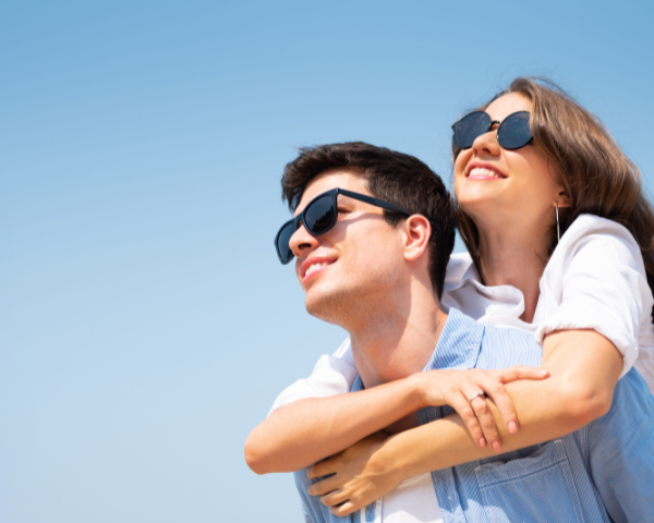 Man and woman smiling wearing sunglasses