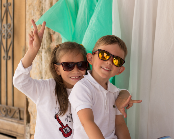 Boy and girl smiling wearing sunglasses