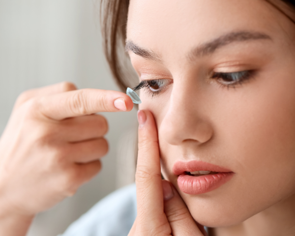 Woman putting a contact lens in one of her eyes