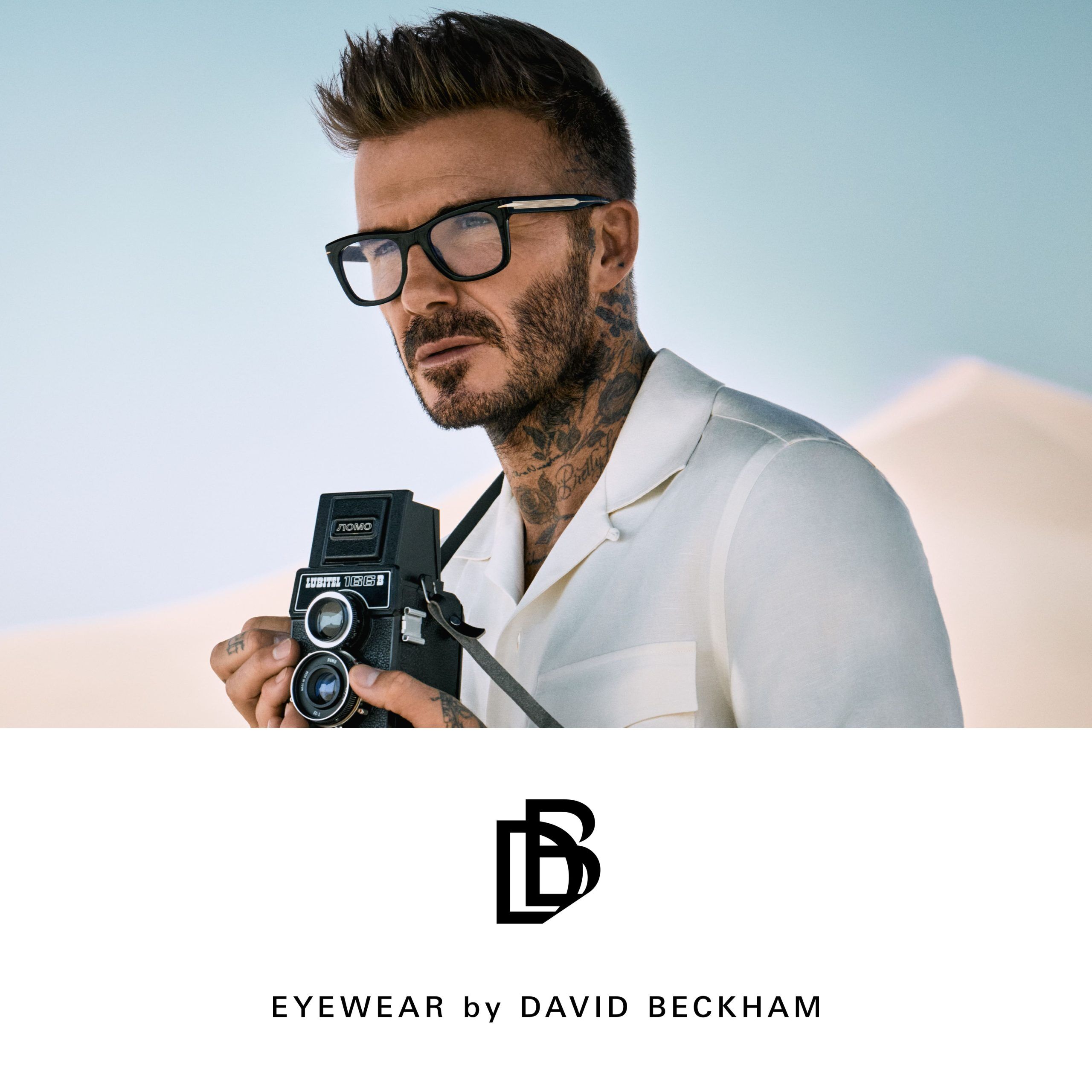 David Beckham wearing eyeglasses holding a camera