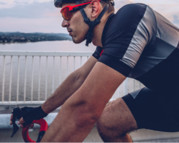 Man wearing cycling sunglasses riding a bicycle