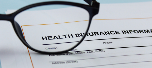 Glasses frame on top of Health Insurance document