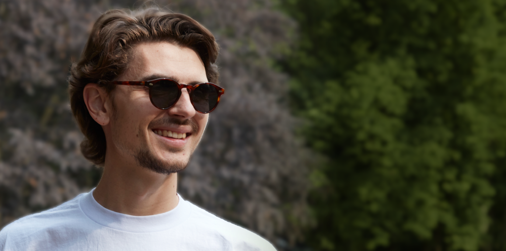 man wearing sunglasses with forest backdrop