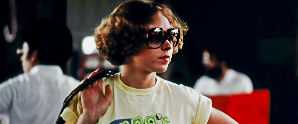 a woman from the 1970s wearing oversized sunglasses