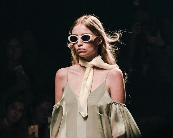 a catwalk model wearing beige sunglasses