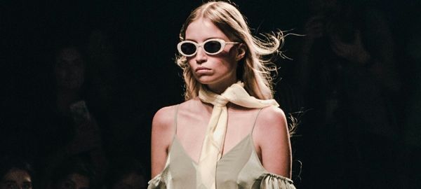 a catwalk model wearing beige sunglasses