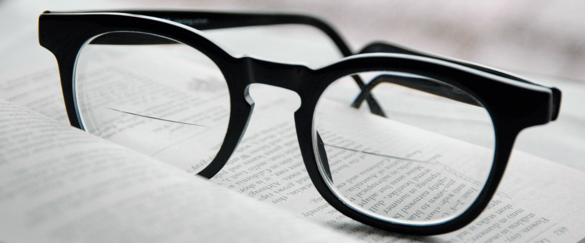 bifocal glasses resting on a newspaper