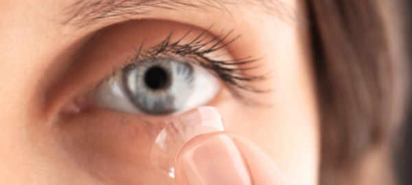 Person putting contact lens in eye