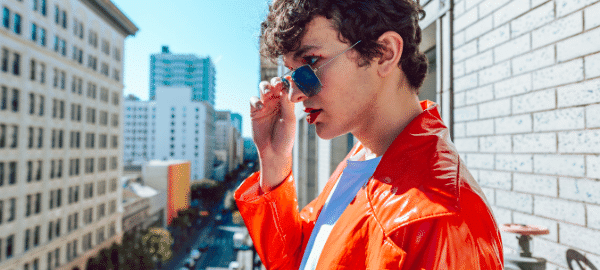 young male model in red jacket wearing funky sunglasses