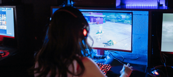 girl gamer playing a computer game wearing headphones