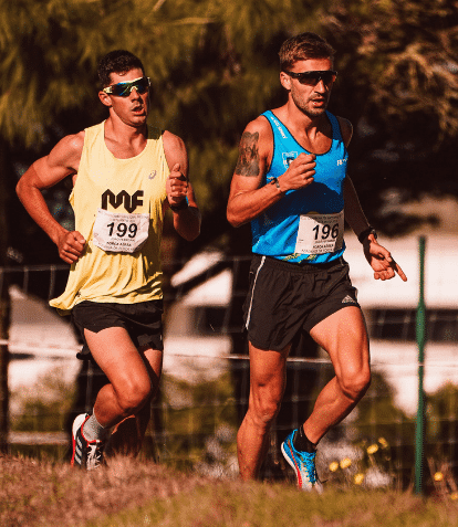 two males running in park wearing sunglasses