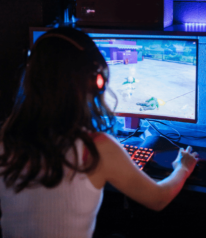 girl gamer playing a computer game wearing headphones