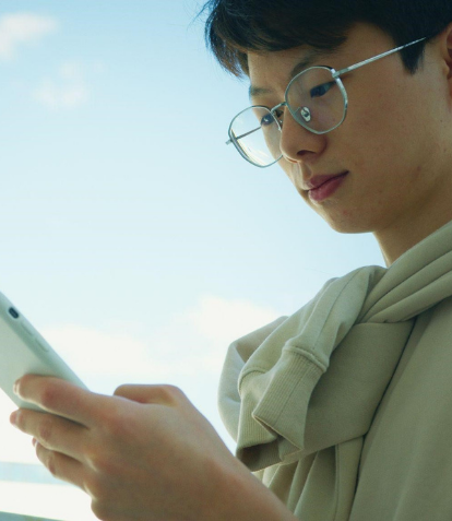 Young Asian adult wearing glasses using his phone