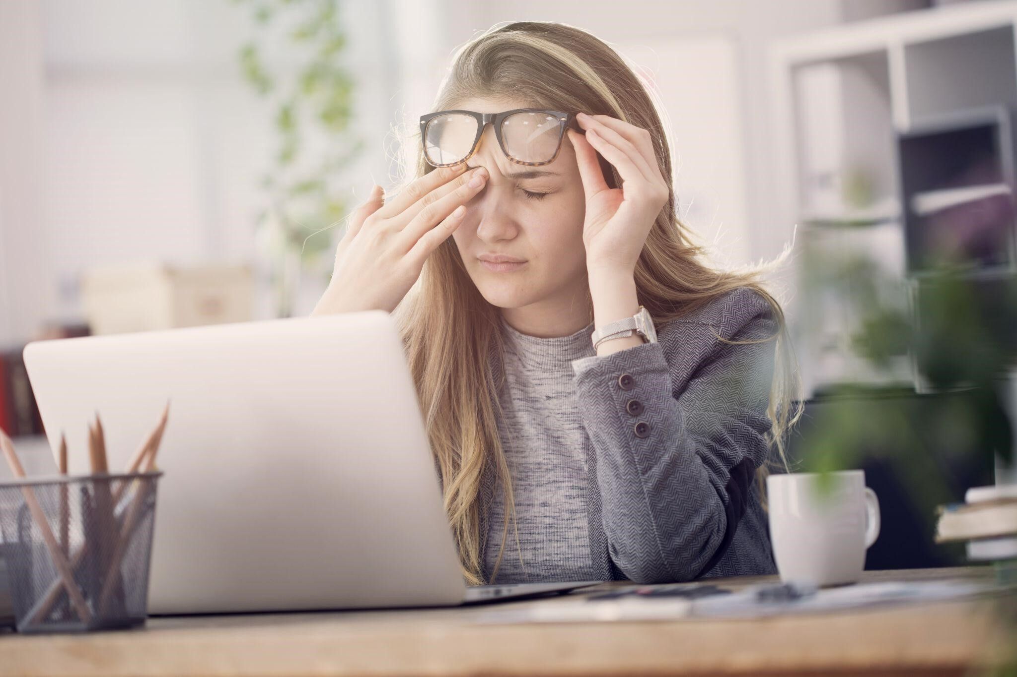 Girl in front of computer rubbing her eyes