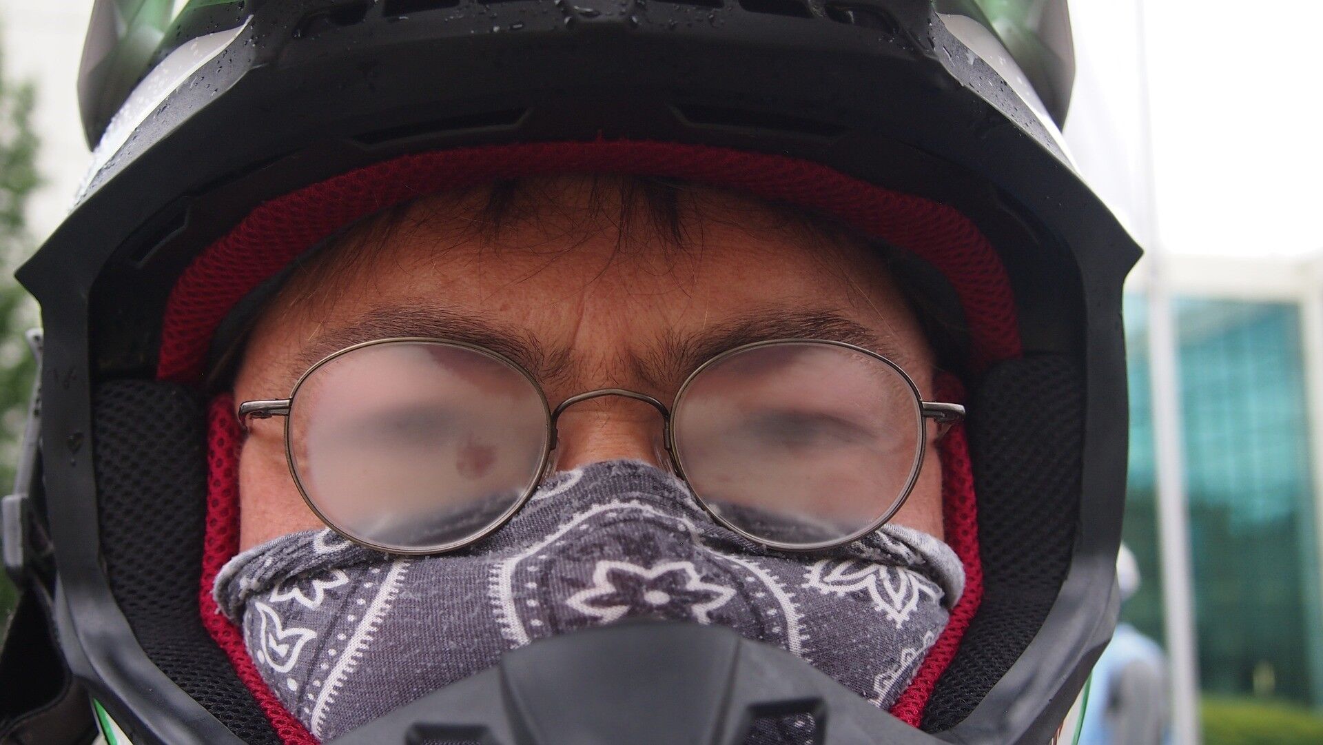 A man wearing a motocycle helment with foggy glasses
