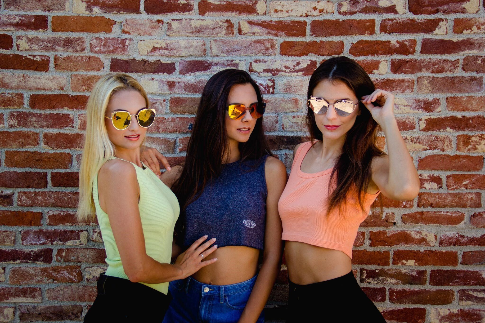 three youthful girls wearing mirrored sunglasses