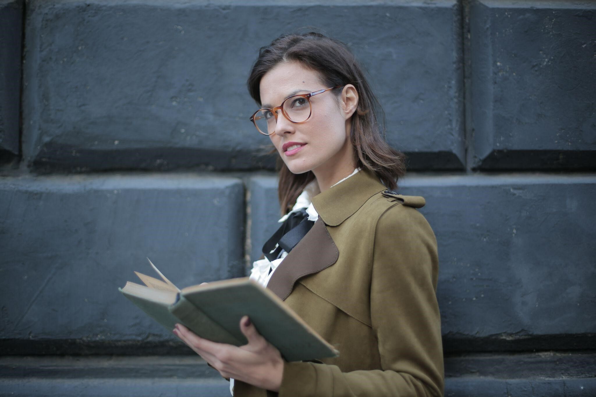Woman wearing glasses holding a book
