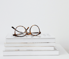 tortoiseshell glasses placed on stack of white books