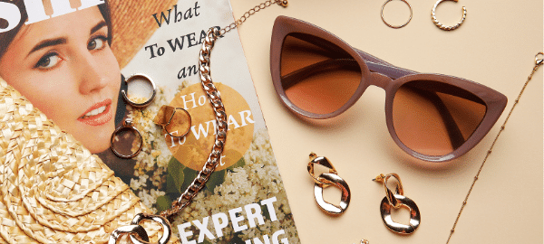 fashionable sunglasses with magazine, rings and necklace