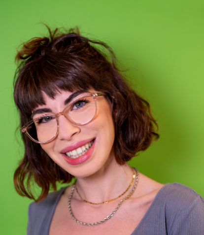 Simling woman wearing clear glasses frames with green background