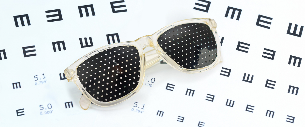a pair of pinhole glasses on an eyechart