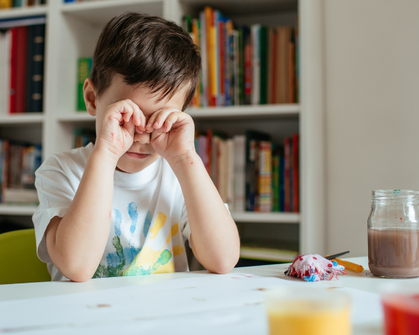boy rubbing his eyes