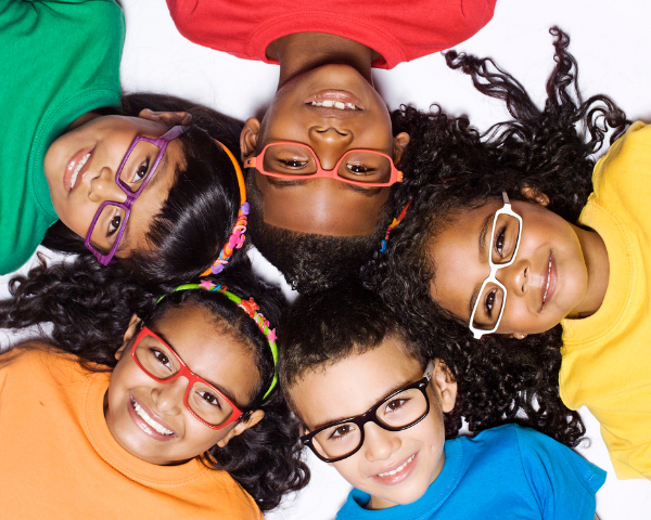 5 children with glasses laying in a circle