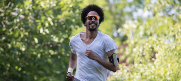 Guy with afro wearing sunglasses while he runs