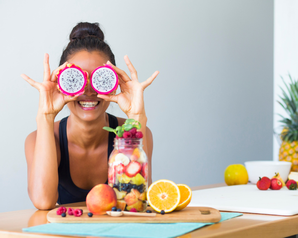 woman posing with fruits that are good for eye health
