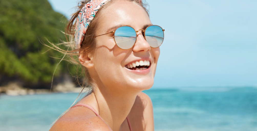 image of a woman at the beach wearing mirrored sunglasses