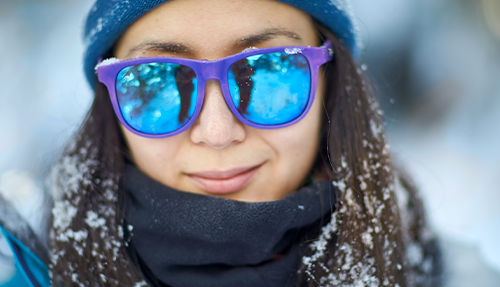 woman in the snow with mirrored sunglasses