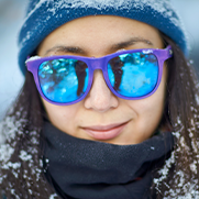 image of a woman in the snow wearing sunglasses with mirrored lenses