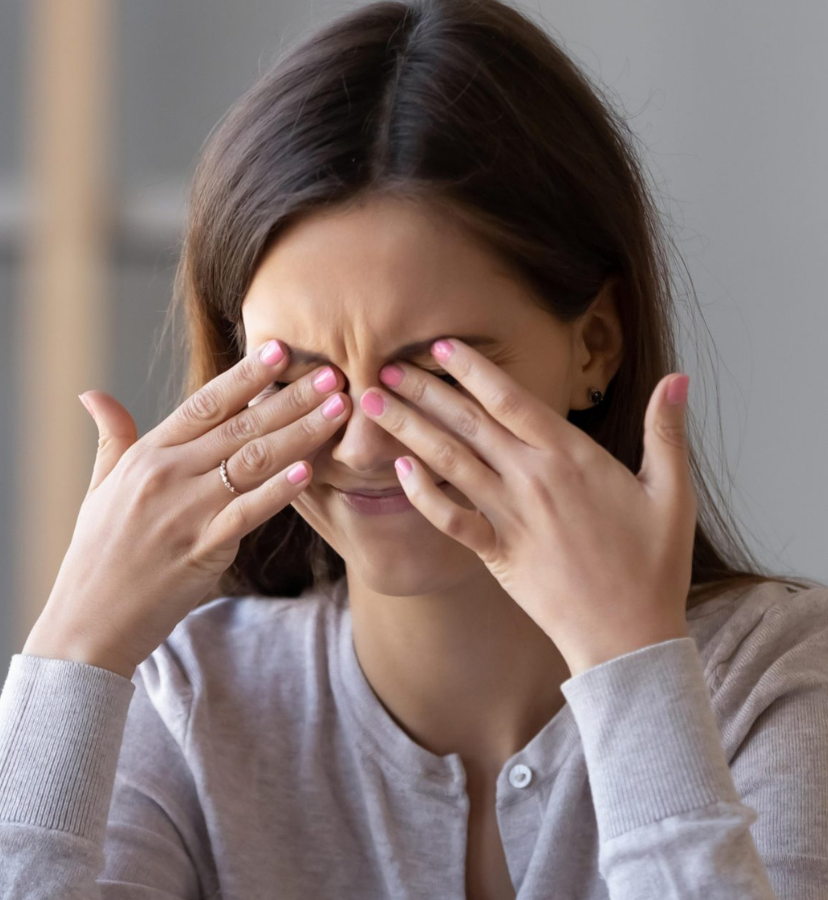 woman sitting at her desk, rubbing her eyes from eye irritation