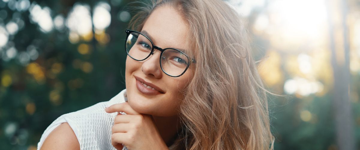 a young woman smiling wearing glasses