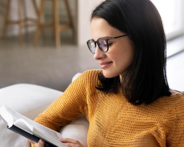 woman wearing glasses and reading a book