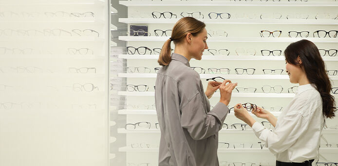 two women browsing glasses in an optical store