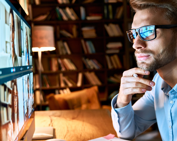 man wearing blue light blocking glasses and looking at LED computer screen